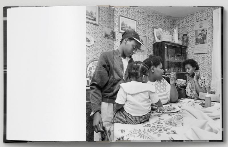 A spread from Roy Mehta's book Revival: London 1989-1993. Two people sit on a table eating food with two children.