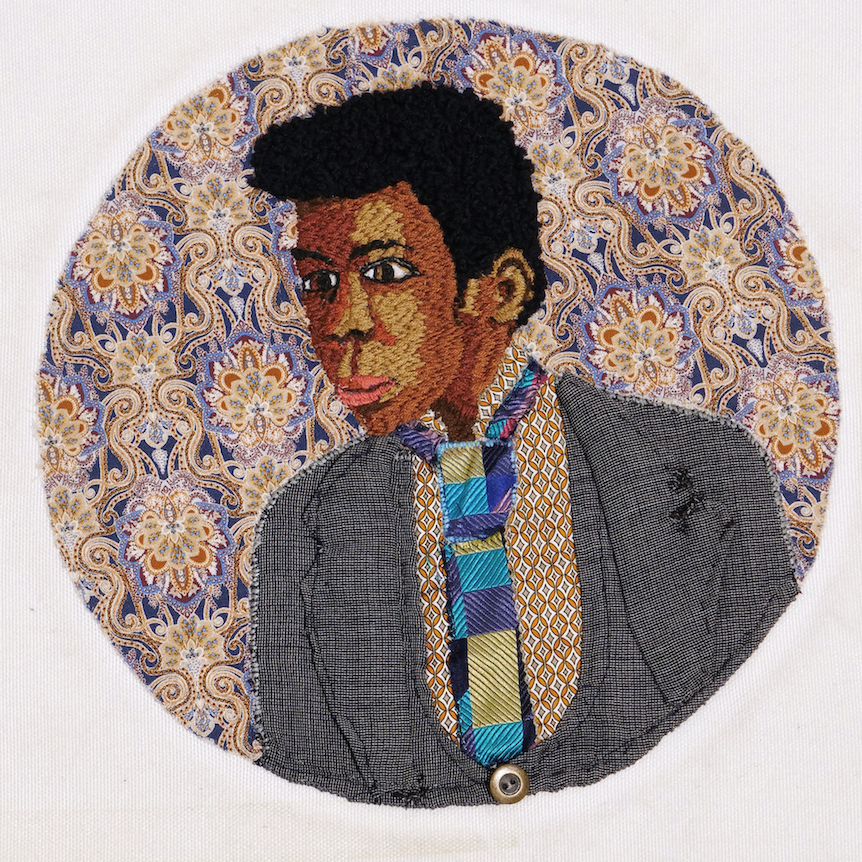 Embroidery of a man with grey suit jacket and blue tie, by member of Headway East London.