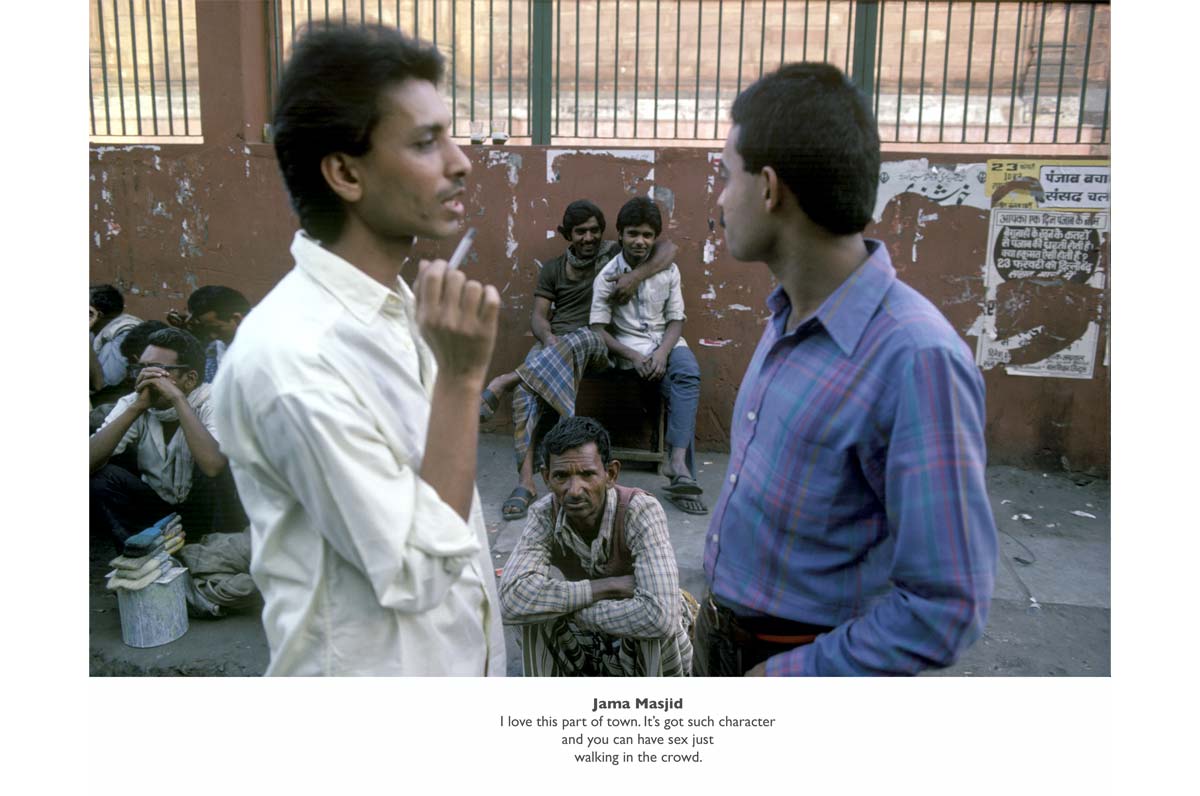 Group of men in India. Two of them are having a conversation and one is smoking a cigarette.